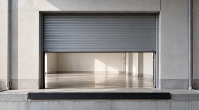 Course cover AI in Procurement: half-open grey roller door at a loading bay, with a bright storage area behind it (AI generated)